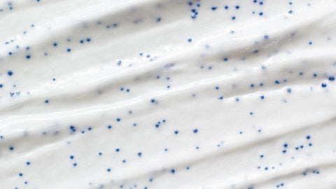 An exfoliating cream close up, focused on the pellet shaped components that remove dead skin cells.