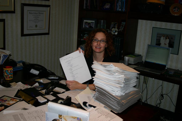 Dr. Baumann at her desk with a stack of completed skin type questionnaires