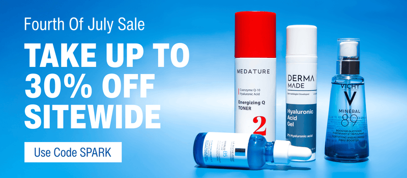 Promotional banner for a July sale showing four skincare products on a blue gradient background with large white text reading 'Fourth Of July Sale', 'TAKE UP TO 30% OFF SITEWIDE', and 'Use Code SPARK'. Visible products include Wedature, Derma Made, and Vichy Minéral 89.