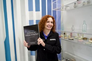 Dr. Baumann holding Baumann's Cosmetic Dermatology, third edition